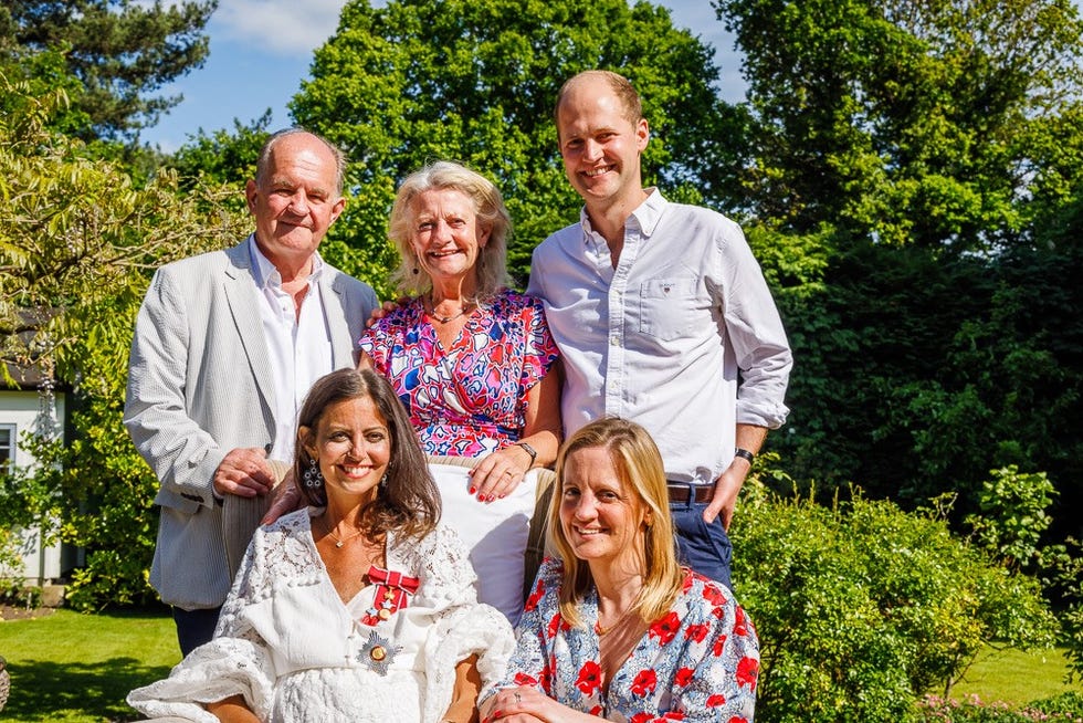 a group of five individuals posing together outdoors