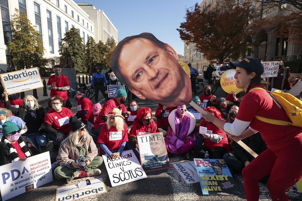 washington, dc   december 01 an activist with the center for popular democracy action holds a photo of us supreme court justice samuel alito as they block an intersection during a demonstration in front of the us supreme court on december 01, 2021 in washington, dc the court heard arguments in dobbs v jackson women's health, a case about a mississippi law that bans most abortions after 15 weeks with the addition of conservative justices to the court by former president donald trump, experts believe this could be the most important abortion case in decades and could undermine or overturn roe v wade photo by chip somodevillagetty images