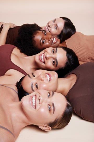 a group of people lying on a bed smiling for the camera