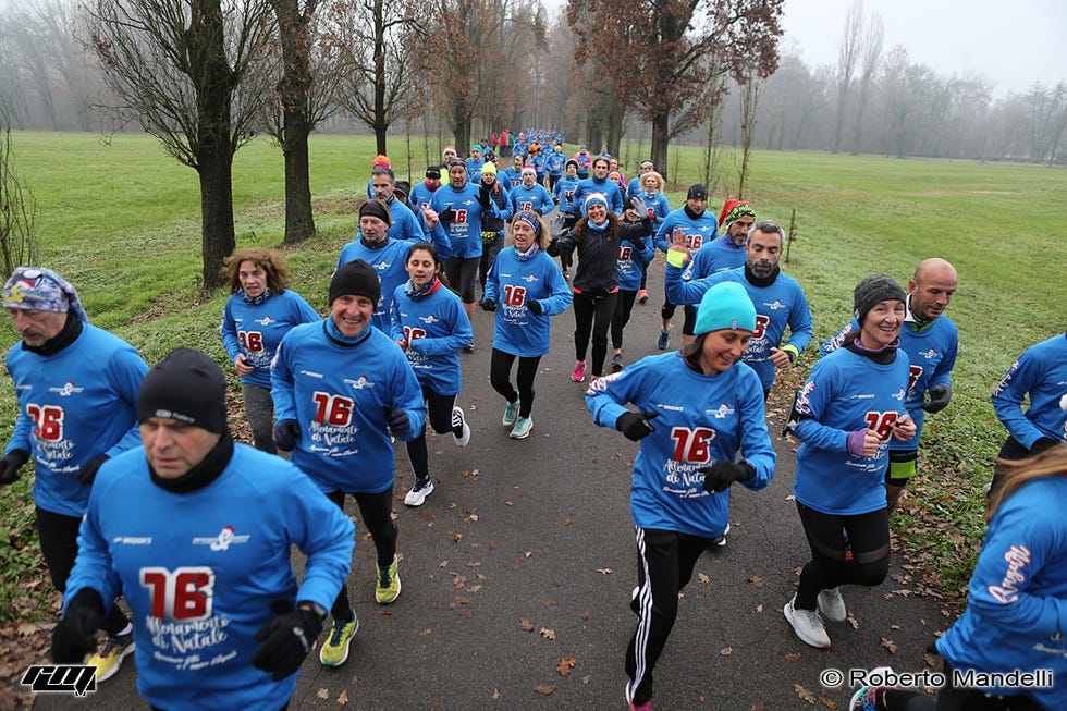 group of runners in blue shirts participating in an outdoor event