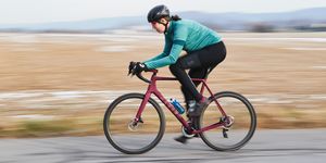 a woman riding a bicycle fast on a road