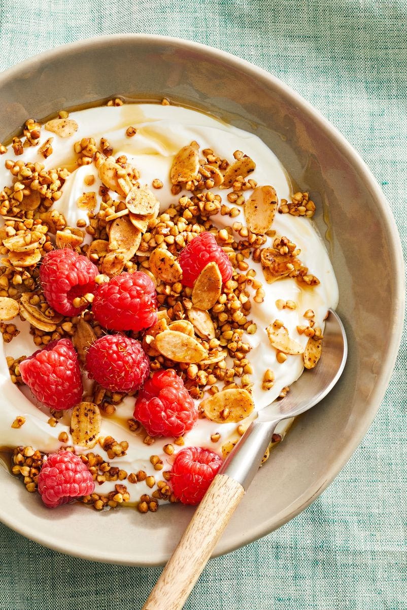 almond buckwheat granola with yogurt and berries in a bowl