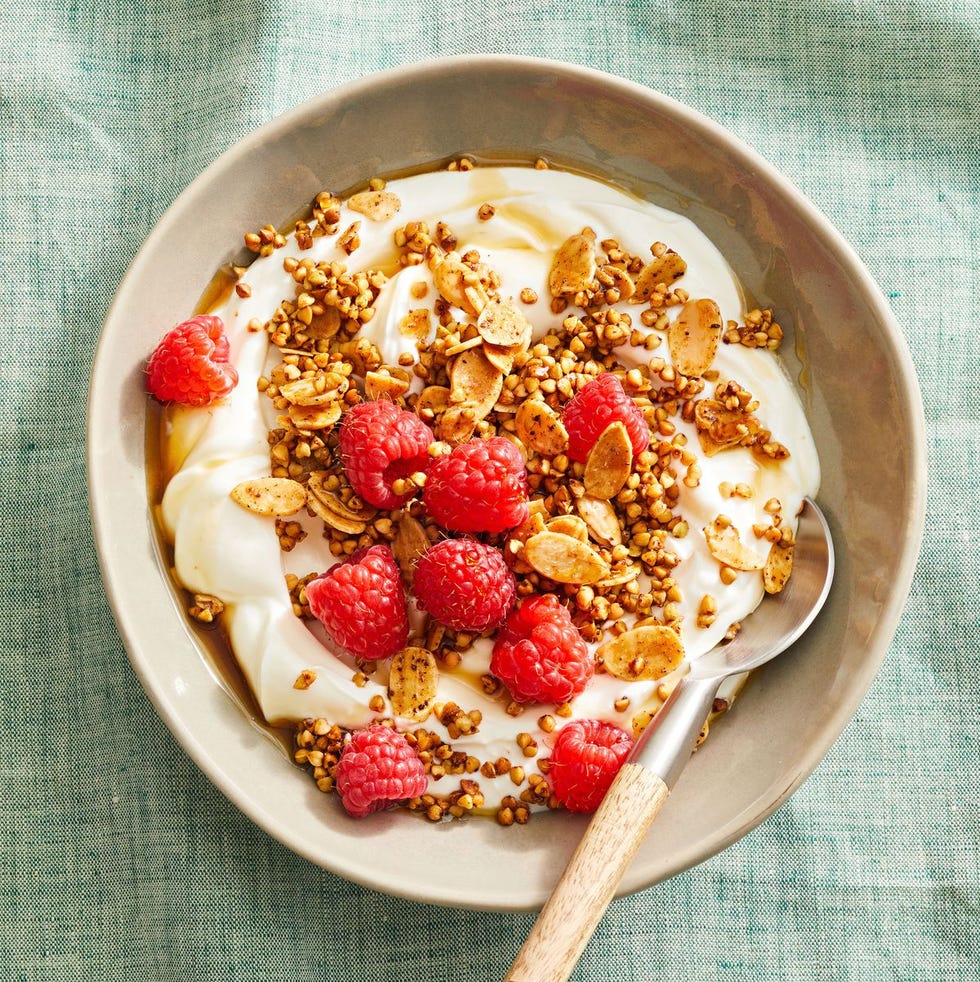 almond buckwheat granola with yogurt and berries in a bowl