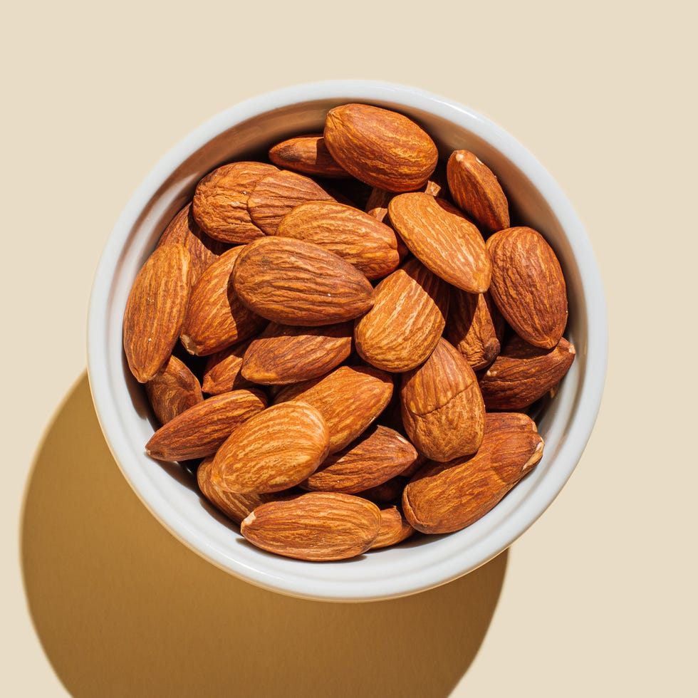 Almond nuts in white bowl n beige background almond nuts in white bowl n beige background