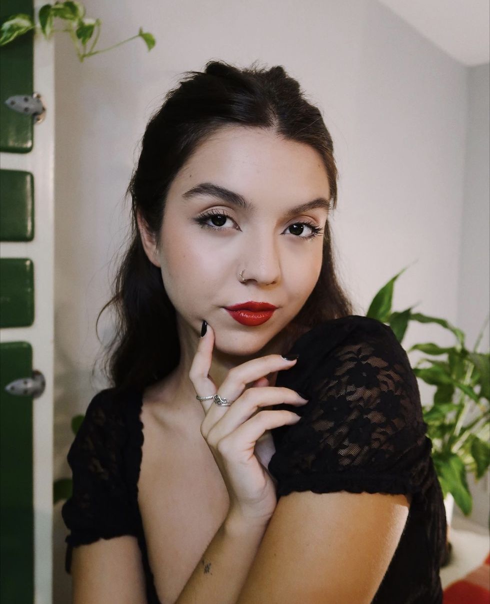 a woman with a black dress and red lipstick