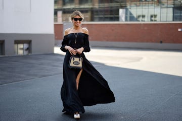 dusseldorf, germany june 04 influencer gitta banko wearing an elegant black off shoulder maxi dress u2018gabinou2019 with leg slits by nicowa, beige and black wedges by schutz, a black belt with gold detail by gucci, sunglasses by bottega veneta, a beige and black bag by gucci, a long gold necklace by lennart marlon and a gold lion necklace by alighieri during a street style shooting on june 4, 2021 in dusseldorf, germany photo by streetstyleshootersgetty images