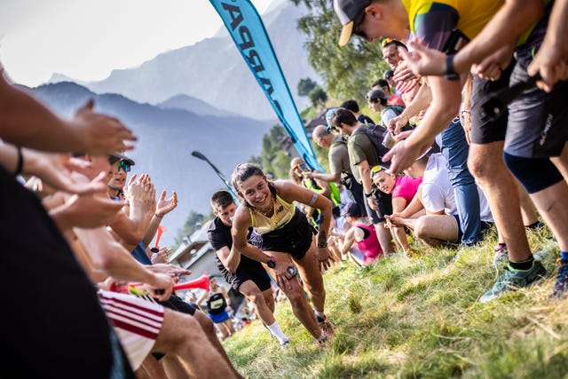 participants encourage runners during a race event in mountainous terrain