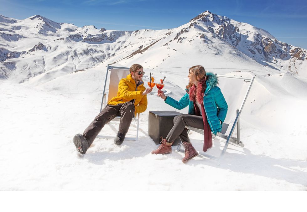 a man and woman sitting on a snowy mountain
