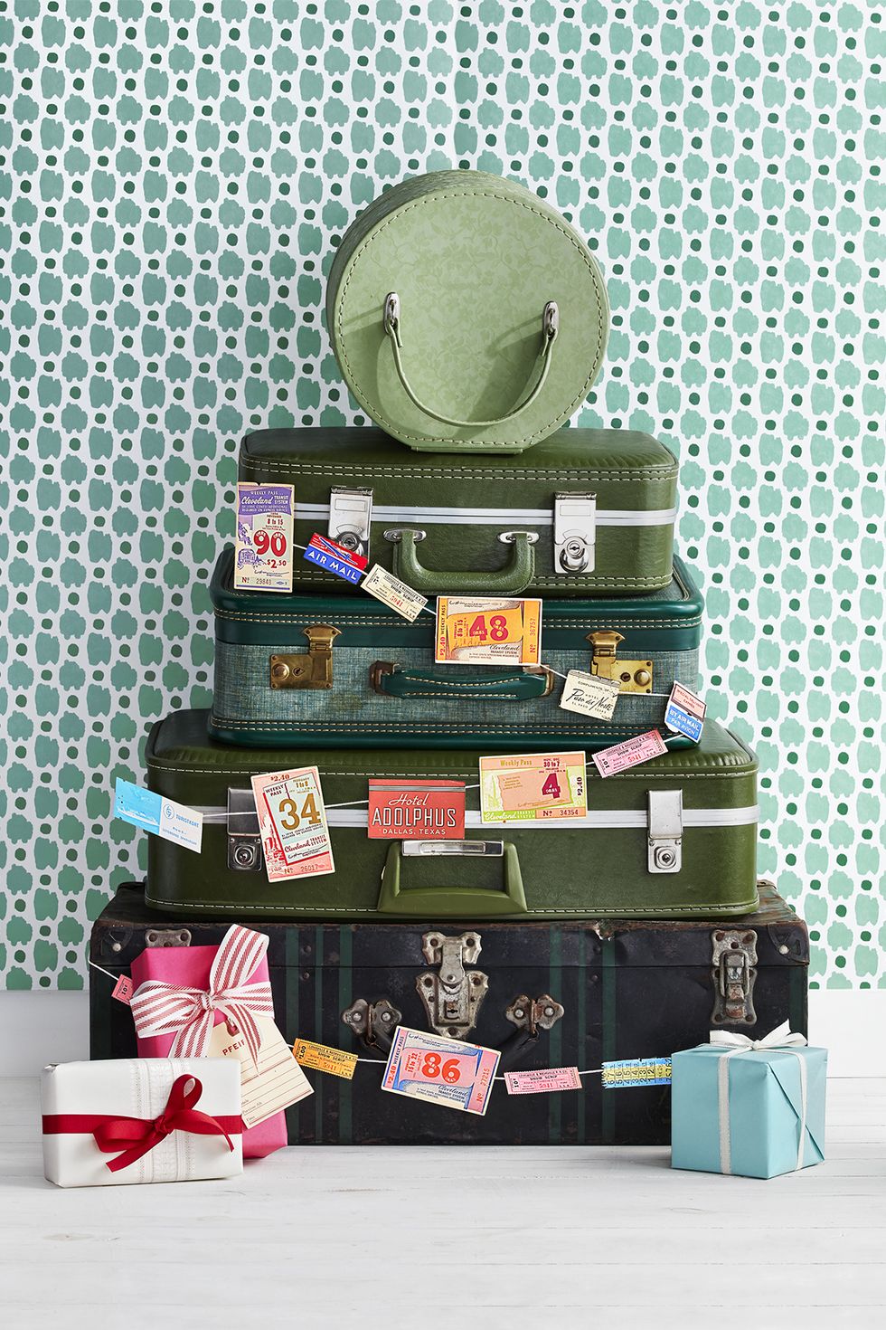 vintage luggage in shades of gree stacked in the shape of a christmas tree