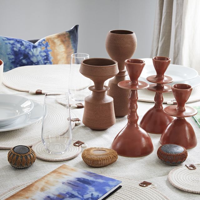 dining table set with place settings, glasses, terra vases, and glazed candlesticks