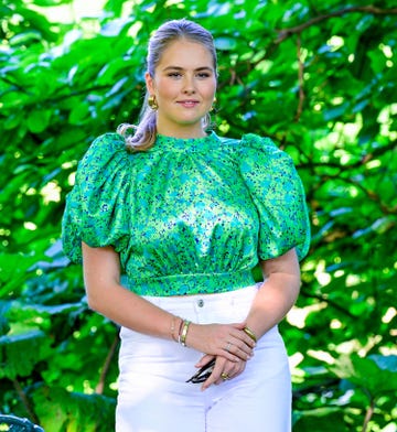 amalia de holanda con blusa verde estampada y vaqueros blancos