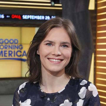 amanda knox smiling at the camera, she wears a black and white patterned dress