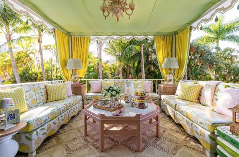 outdoor terrace room with two floral patterned sofas surrounding a pink coffee table