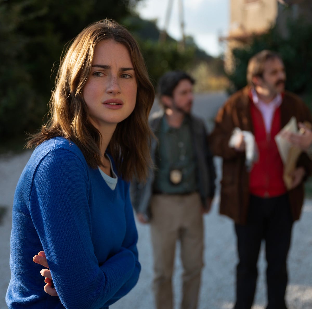 Grace Van Patten as Amanda Knox in the Hulu series 'The Twisted Tale of Amanda Knox' young woman looking past frame nervously as people speak in the background