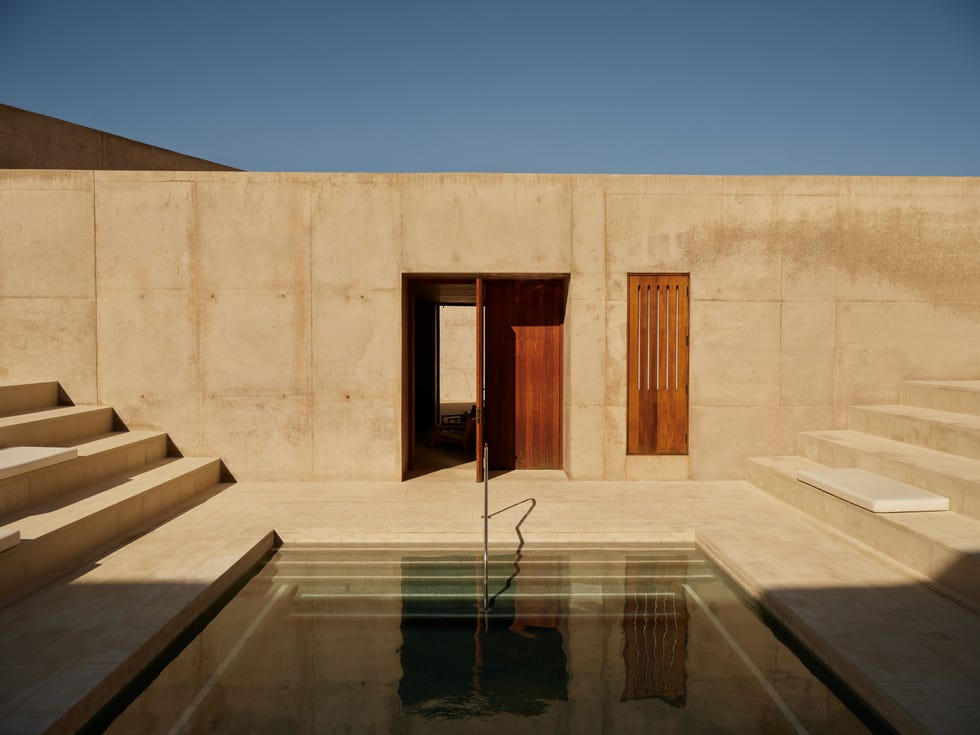 private pool area with textured concrete walls and wooden doors