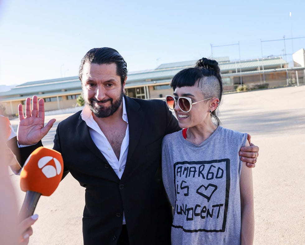 a man and woman posing for a picture with their hands up