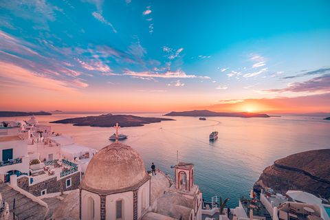 amazing evening view of fira, caldera, volcano of santorini, greece with cruise ships at sunset cloudy dramatic sky