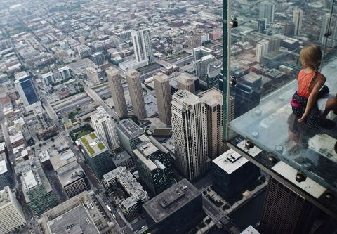 Op 413 meter hoog geeft het luchtdek van de Willis Tower in The Windy City uitzicht op een doolhof van grijze daken  en een groene