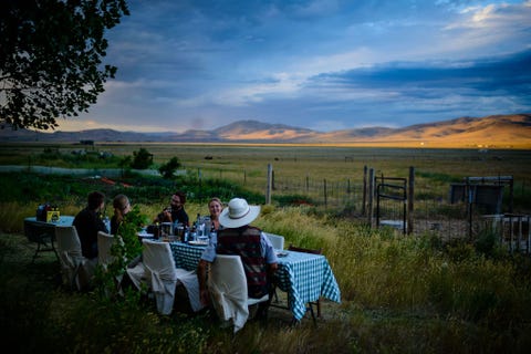 Familie vrienden en seizoensboeren genieten van een diner op een boerderij in Montanas Camas Prairie