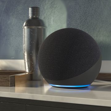 amazon echo 4th gen in dark grey with blue underlight, pictured on a sideboard next to a cocktail shaker