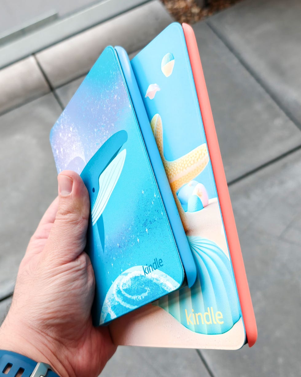 two kids kindle ereaders held in a hand showcasing their colourful cover designs