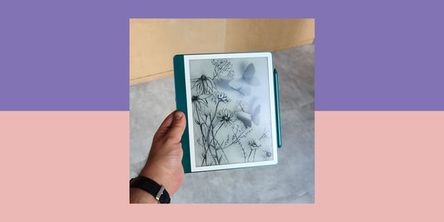amazon kindle scribe ereader displaying a floral and butterfly design held in a persons hand