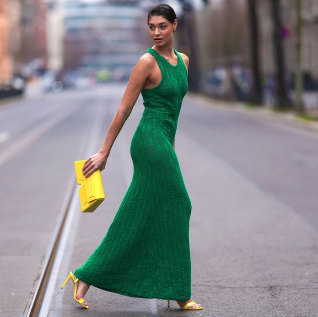 a woman in a green dress walking down a street