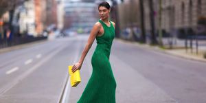 a woman in a green dress walking down a street