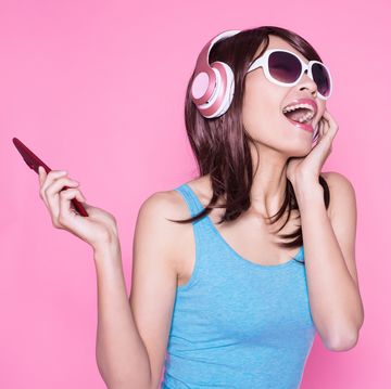 woman listening to music on phone, with wireless headphones