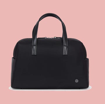 a black handbag on a pink background