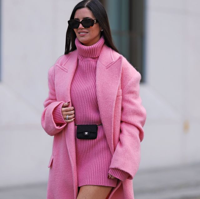 a woman wearing a pink coat and sunglasses