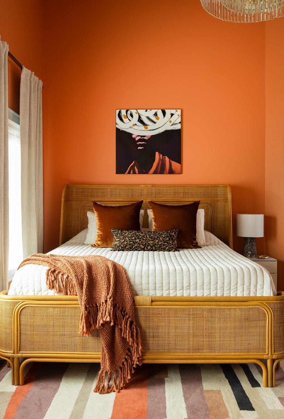 bedroom with orange walls and caned headboard