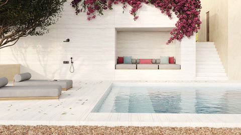a pool area with white stone walls and floors