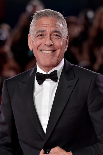 george clooney smiles and looks right, he wears a black suit jacket, black bow tie and white collared shirt