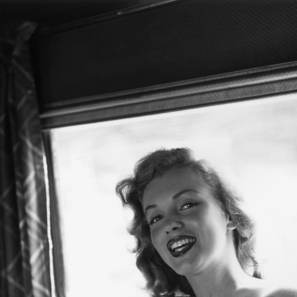 june 1949: exclusive american actor marilyn monroe (1926 1962) sitting on a train to warrenburg, new york, to present the keys to a new house to a winner of a photoplay magazine contest. monroe was accompanied on the trip by don defore and lon mcallister. (photo by hulton archive/getty images)