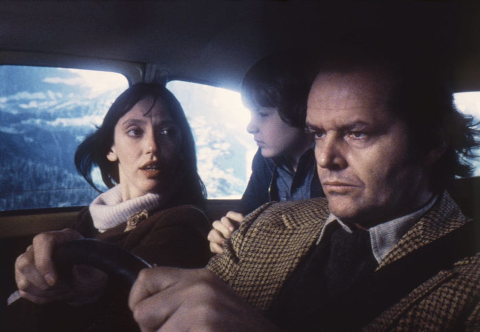 shelley duvall, danny lloyd, and jack nicholson ride in a car during a scene in ﻿the shining, nicholson drives with duvall in the passenger seat and lloyd in the backseat