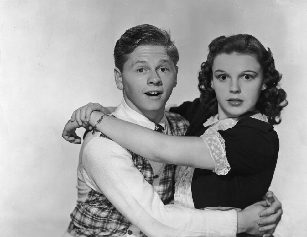 Rooney & Garland　circa 1938: American actors Mickey Rooney and Judy Garland hug and look at the camera with surprised expressions, in a promotional portrait for director George B. Seitz's film, 'Love Finds Andy Hardy.'