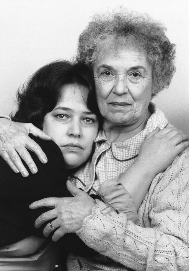 two women embrace as they stare at the camera in front of them