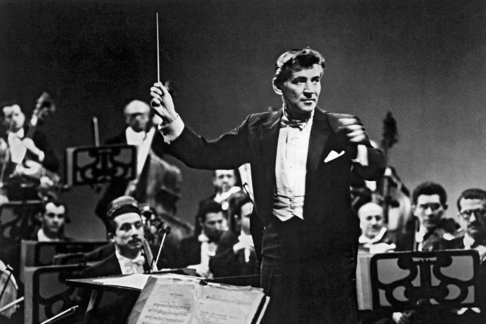 a black and white photo of leonard bernstein conducting the new ﻿york philharmonic