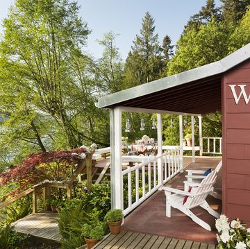 red coastal cottage with adirondack chairs and view of lake