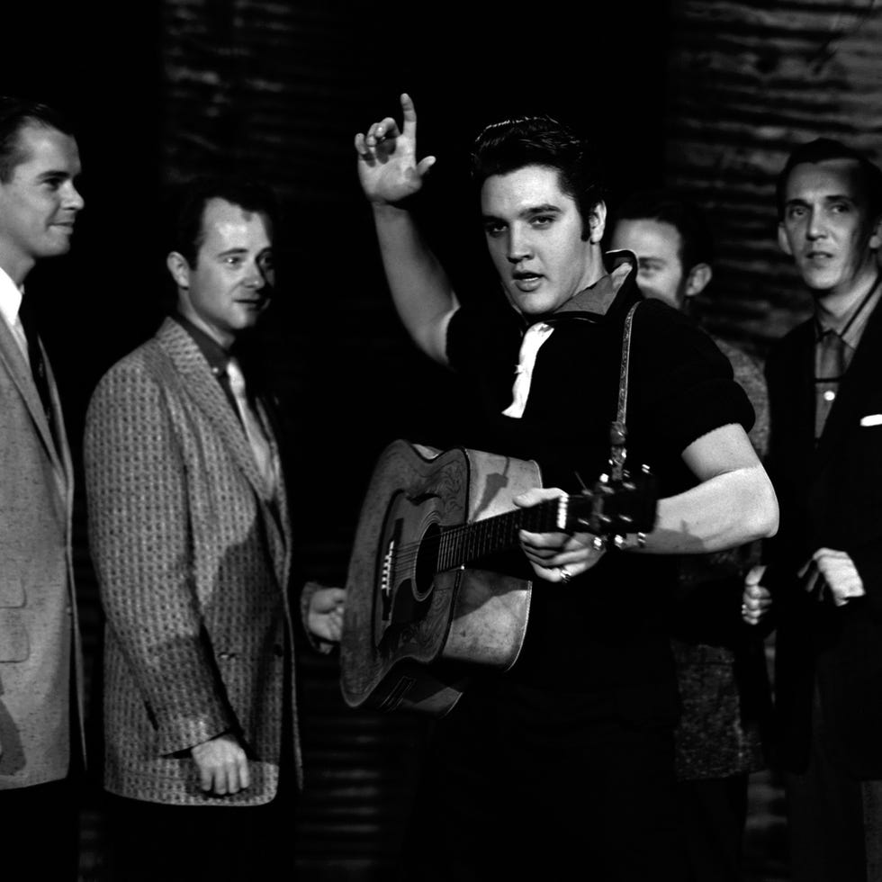 elvis presley holding his guitar while rehearsing for a performance