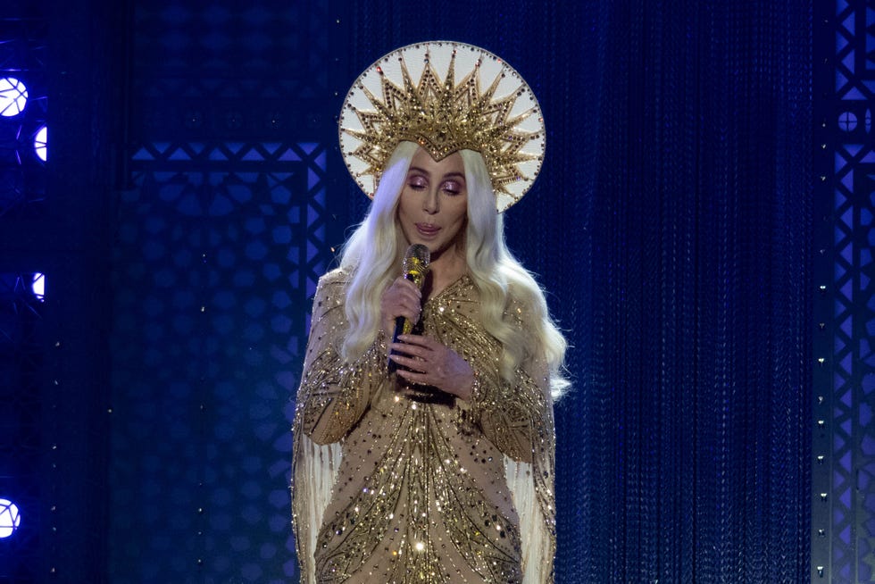 cher in concert wearing golden gown and halo