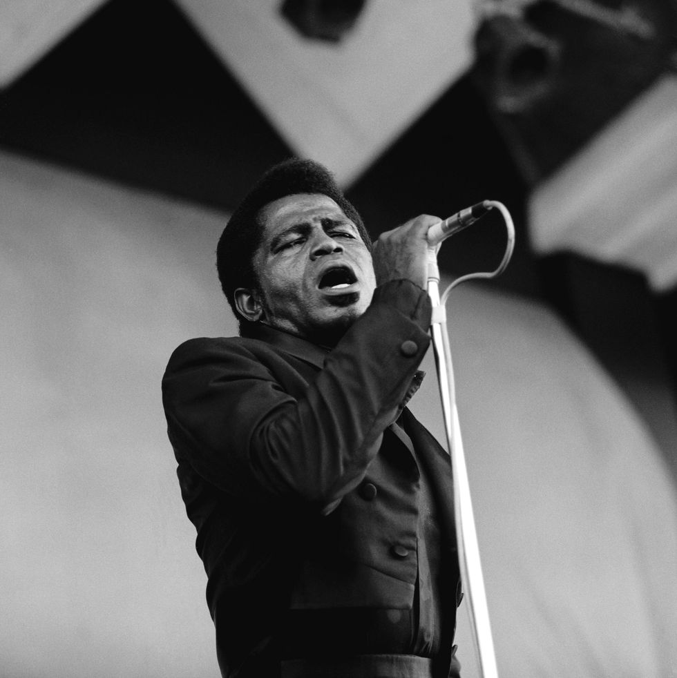 james brown holding a microphone during a singing performance