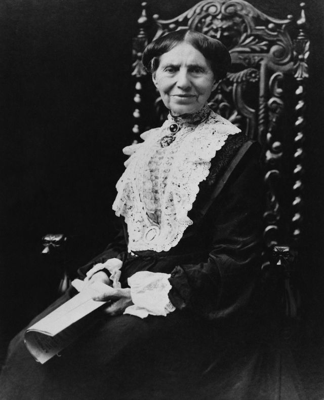 clara barton sitting in a chair and holding a pamphlet