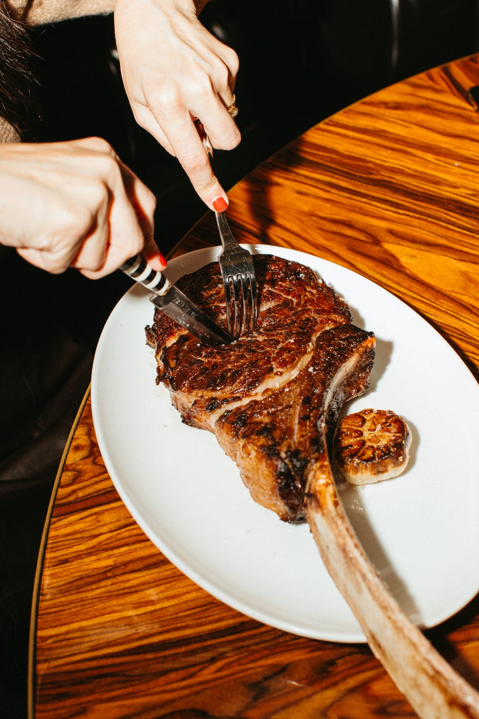 a person cutting a piece of steak