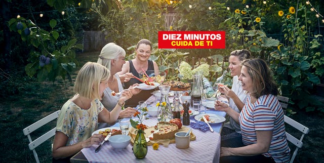 un grupo de mujere sentadas alrededor de una mesa en un jardín