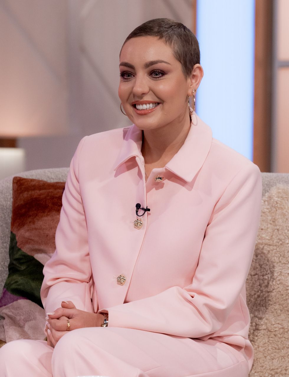 Amy Dowden luciendo una gran sonrisa y una camisa rosa pálido en Lorraine.