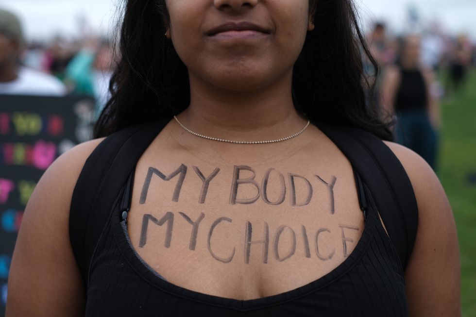 an abortion rights demonstrator has the words my body m