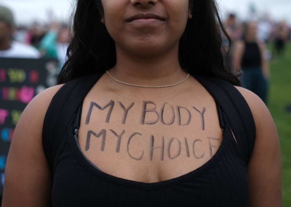 an abortion rights demonstrator has the words my body my