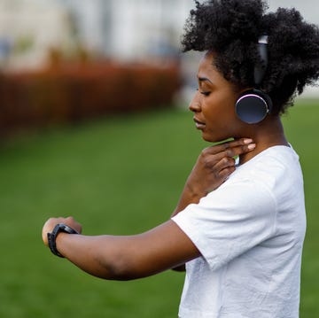 an african woman is checking his heart rate after a training